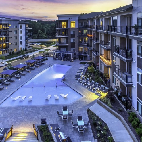 Everything within reach a courtyard with tables and chairs and buildings with a sunset in the background
